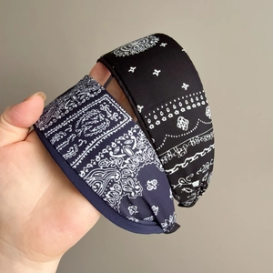 Detail of cross-knot paisley headbands in black and navy blue twill fabric texture