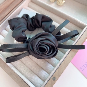 Élastique à cheveux rose en satin noir élégant avec rubans dans une boîte à bijoux