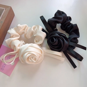 Détail de chouchous rose en satin fait main noir et crème avec de longs rubans élégants