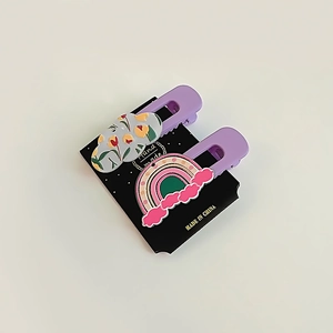 Détail de pinces à cheveux violettes avec motifs de nuages floraux et arc-en-ciel