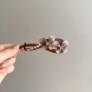 Dettaglio molletta per capelli a farfalla in resina ambrata con strass scintillanti