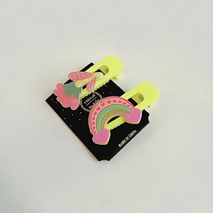 Détail de pinces à cheveux jaunes avec breloques mignonnes fraise et arc-en-ciel