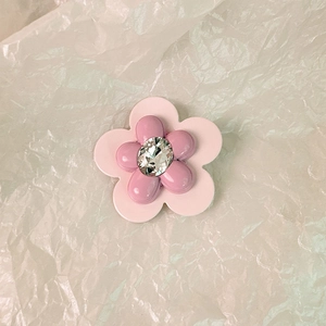 Dettaglio di un fermaglio per capelli a doppio fiore rosa con cristallo centrale lucido