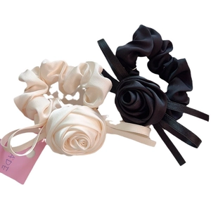 Chouchous élégants en satin avec roses et rubans en noir et blanc pour les cheveux