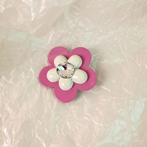 Dettaglio della molletta a fiore rosa e bianca con cristallo scintillante al centro