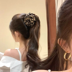Leopard print floral hair scrunchie and gold earrings on model shown in mirror reflection