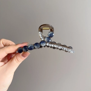 Sparkling crystal shark hair claw clip in translucent grey with blue glitter bead detail