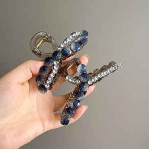 Detail of large resin hair claw clip with blue glitter beads and sparkling rhinestones