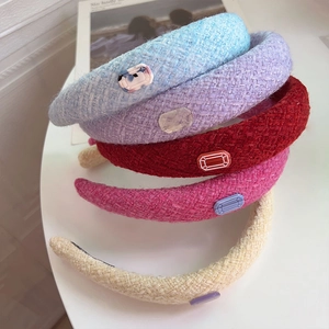 Detailed close-up of thick tweed headbands with resin gemstones in various colors