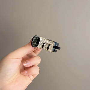 Black mini hair claw clip with crystal M letter embellishment for women's side styling