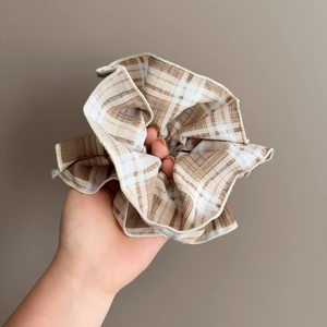 Gros plan détaillé du chouchou géant à carreaux marron et blanc en tissu doux