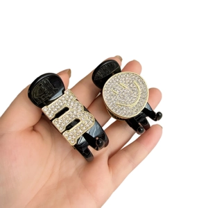 Black mini hair claw clips with sparkling crystal M letter and smiley face motifs