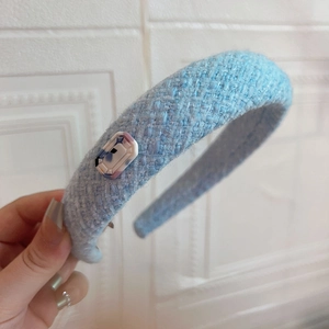 Light blue tweed headband with rectangular purple marble accent and padded fabric texture