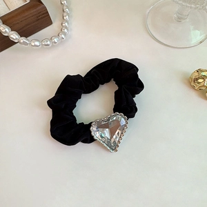 Sparkling rhinestone heart hair scrunchie in black fabric on an elegant background