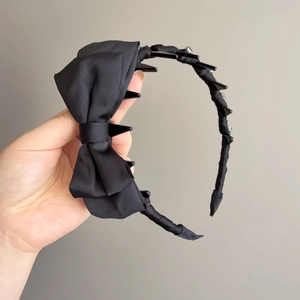 Detail showing black ribbon headband with small hair clips and sparkling rhinestones