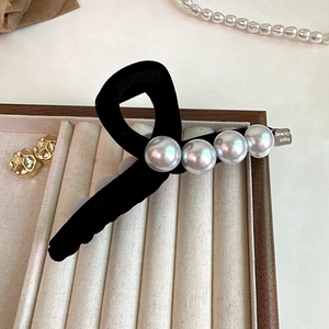 Pince à cheveux nœud floqué noir élégante avec perles et breloque sur plateau déco