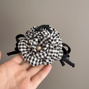 Vue détaillée d'une grande pince à cheveux rose avec tissu vichy et perle élégante