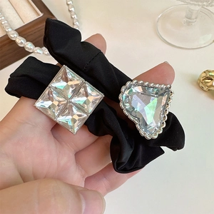 Detail of elegant black satin hair tie with sparkling heart and square crystal charms