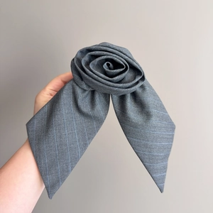 Détail d'un accessoire de cheveux rose en tissu rayé gris avec texture élégante