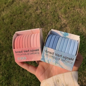 Set of 2 boxes featuring pink and blue gradient high-elastic hair ties on green grass