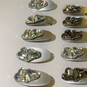 Detail of matte silver duckbill clips featuring overlapping faceted heart crystals