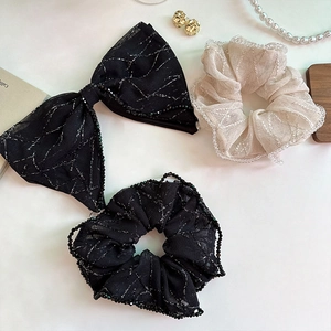 Detail of sheer mesh hair scrunchies and bow clip with silver lines and beaded edges
