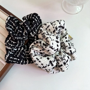 Detailed view of black and white tweed scrunchies with elegant textured knit pattern