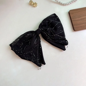 Detail of black mesh hair scrunchie with silver geometric texture and bead trim