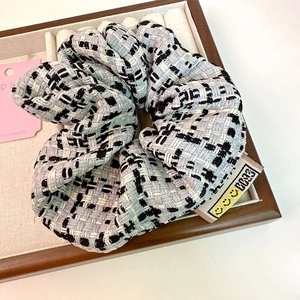 Tweed plaid scrunchie with smile face label on a jewelry tray for women hair styling