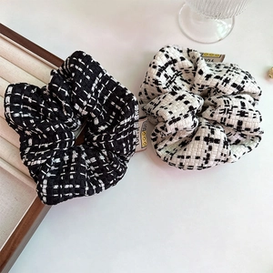 Detail of tweed scrunchie set with woven texture and small smile face fabric label