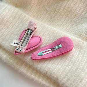 Set di fermagli per capelli in feltro rosa con cuore su sfondo in maglia