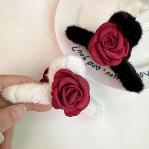 Detailed view of elegant plush hair claw clips with dark red satin rose decorations