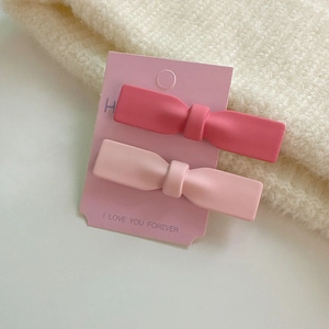 Lot de deux pinces à cheveux rose mat sur carte de présentation esthétique