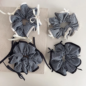 Close-up of black and white plaid scrunchies with bows and pearls on a vintage book