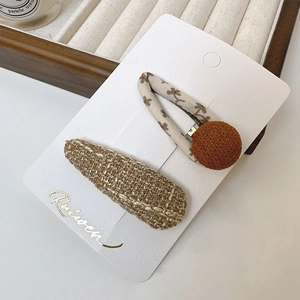 Détail du clip BB en tissu floral et épingle à cheveux en tweed sur carte élégante