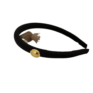 Minimalist black wide headband with vintage gold button detail on white background
