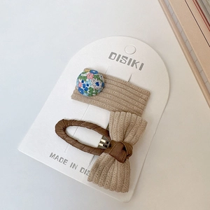 Détail de barrettes à cheveux avec bouton fleuri et nœud en velours côtelé
