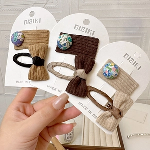 Détail montrant la texture du velours côtelé et le bouton fleuri sur les barrettes