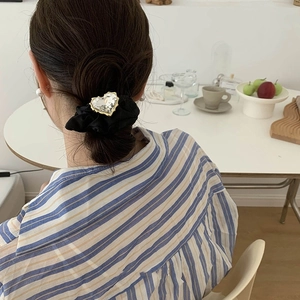 Elegante elastico per capelli nero con grande cuore di cristallo indossato da modella