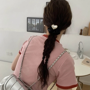 Dettaglio dell'elastico per capelli nero con ciondolo a cuore in strass scintillanti