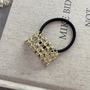 Vue détaillée d'un chouchou noir avec accessoire métallique doré à motif d'étoiles