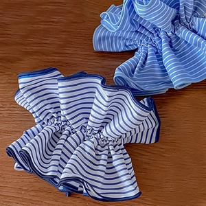 Vue détaillée de chouchous en tissu à rayures bleues et blanches sur bois sombre
