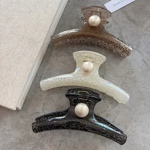 Detail of vintage textured large hair claw clips with elegant pearl embellishment