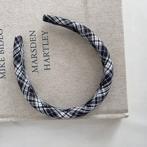 Detail of classic black and white plaid fabric headband on a textured vintage book cover
