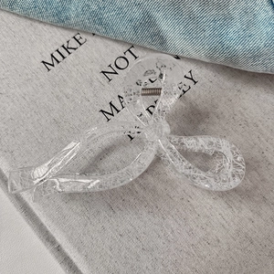 Medium lace pattern hair claw clip in bow shape with transparent resin and silver spring