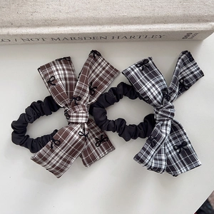 Detailed macro view of plaid bow hair ties in brown and grey retro preppy style