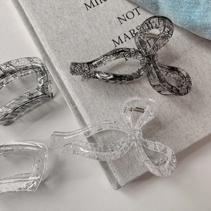 Lace pattern hair claw clips in bow and rectangle shapes with elegant black and white designs