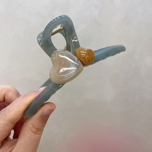 Détail de la pince à cheveux en acrylique bleu avec cœurs et ressort en métal