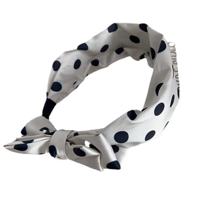 Elegant polka dot bow headband in cream and black silk texture for stylish women