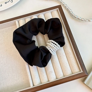 Detail of black silk scrunchie with five layers of elegant pearl embellishments